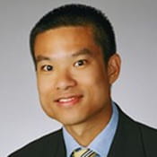 Headshot of Dr. Gregory Huang. Dr. Huang is wearing a suit and has short hair.